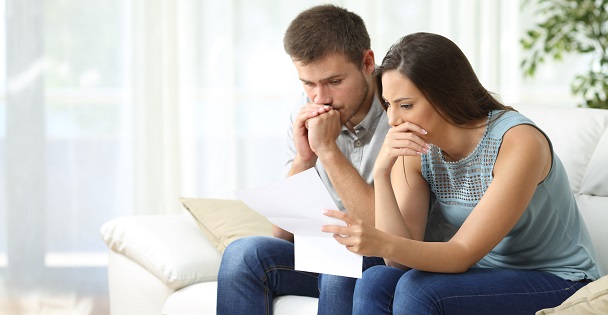 Worried couple reading about deceased debts